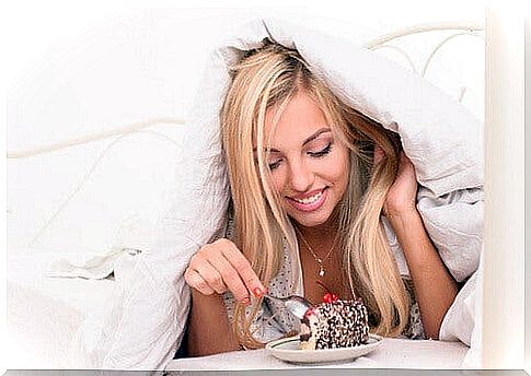 Woman eating a cake in bed