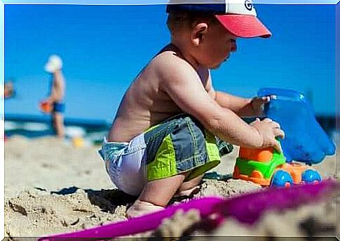 Boy on the beach with toy car
