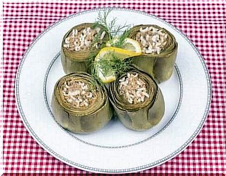 Four rice-filled artichokes on a white plate