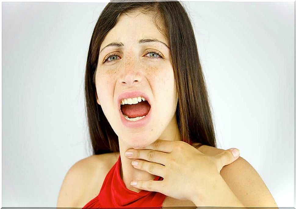 Woman touches sore throat with hand