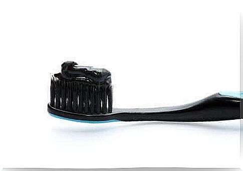 A toothbrush with charcoal toothpaste on it
