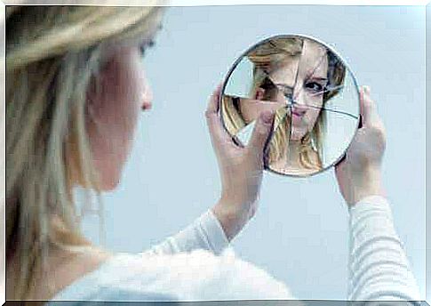 Woman looks in a broken mirror