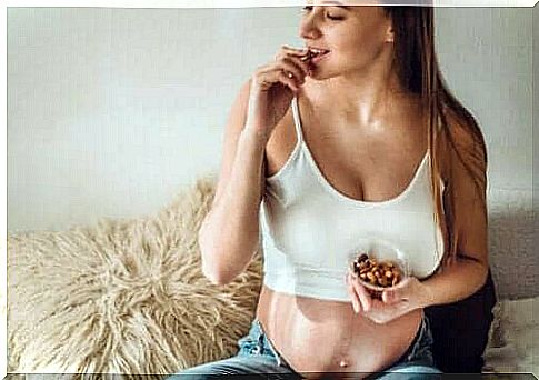 A pregnant woman eating almonds